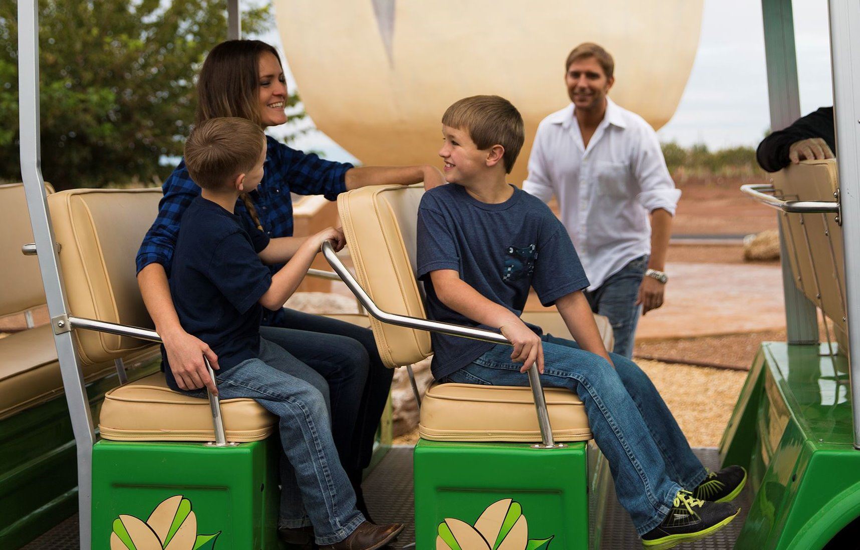 A family enjoys the world's largest pistachio in a golf cart tour.